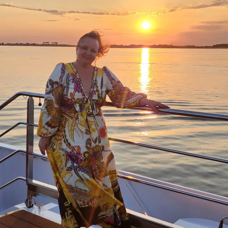 Enjoy a golden sunset cruise Sun setting behind Sandra on a cruise boat