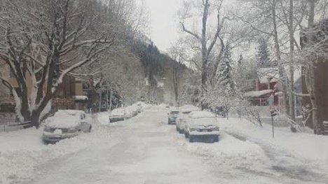 Cars sitting still in a snowy street in Aspen